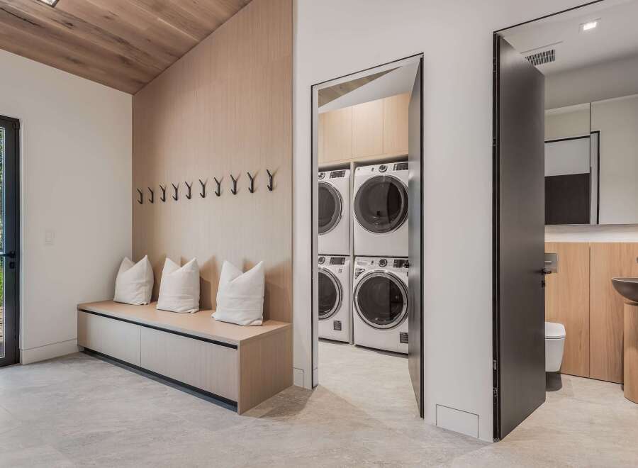 Discover modern living with this spacious laundry room featuring stacked washers and dryers for ultimate convenience.