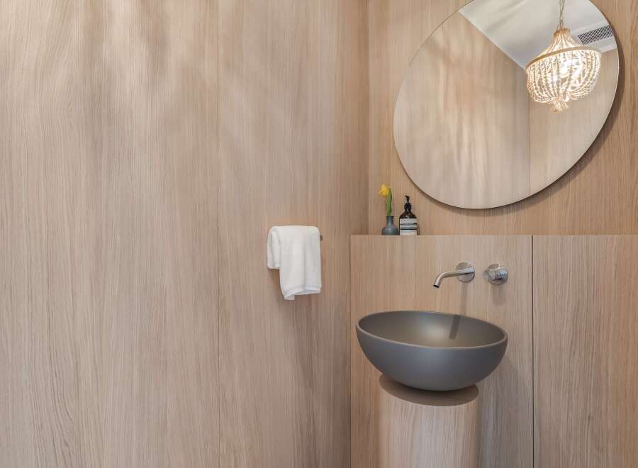Experience modern luxury in this bathroom featuring a sleek, wall-mounted faucet and a stylish vessel sink.