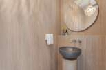 Experience modern luxury in this bathroom featuring a sleek, wall-mounted faucet and a stylish vessel sink.