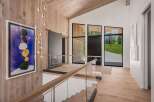 Experience modern luxury in this stunning entryway featuring a dramatic multi-tiered chandelier and a striking abstract art piece.