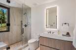 Experience modern luxury in this stunning bathroom, featuring a spacious walk-in shower with marble tile and a sleek vanity with a minimalist design.