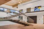 Experience modern luxury in this stunning home featuring a floating staircase with glass railings and warm wood accents.
