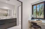 Experience modern luxury in this stunning bathroom featuring a sleek double vanity with integrated sinks and a large, illuminated mirror.