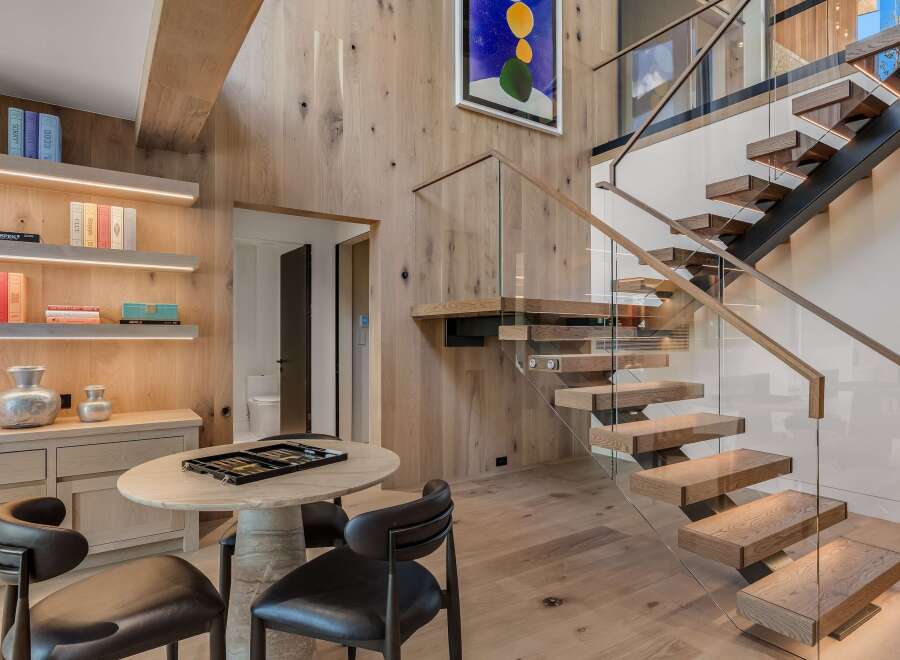 Experience modern luxury in this stunning home featuring a floating staircase with glass railings and warm wood accents throughout.