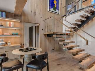 Experience modern luxury in this stunning home featuring a floating staircase with glass railings and warm wood accents throughout.