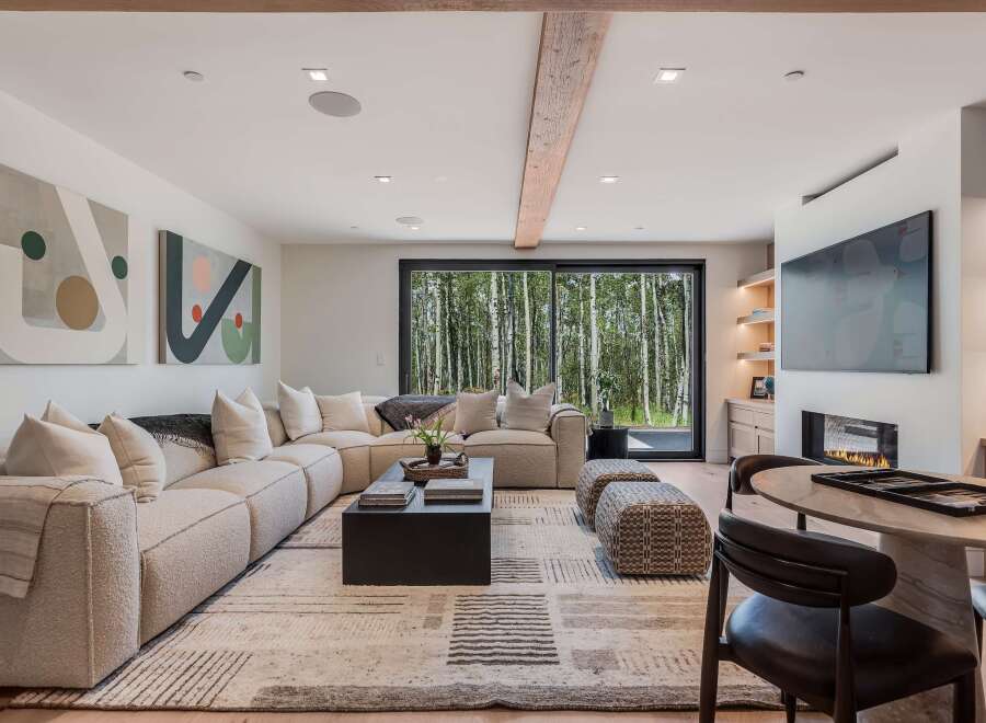 Experience modern living with this stunning living room, featuring a plush sectional sofa and a sleek black coffee table.