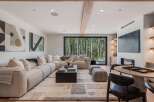 Experience modern living with this stunning living room, featuring a plush sectional sofa and a sleek black coffee table.