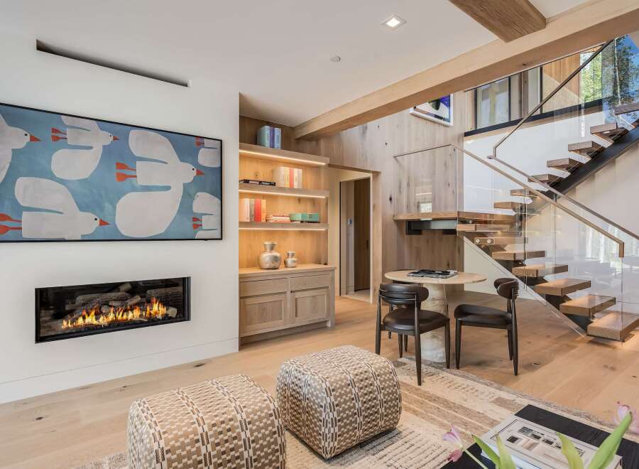 Experience modern luxury in this stunning living space, featuring a sleek gas fireplace and a captivating art piece.