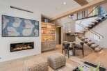 Experience modern luxury in this stunning living space, featuring a sleek gas fireplace and a captivating art piece.