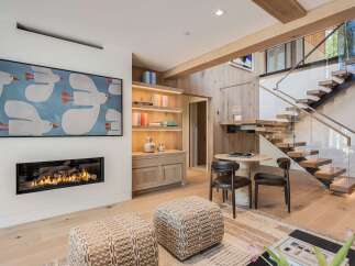 Experience modern luxury in this stunning living space, featuring a sleek gas fireplace and a captivating art piece.