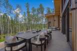 Enjoy al fresco dining with this stunning outdoor patio featuring a large dining table and comfortable seating, perfect for entertaining guests.