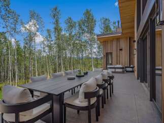 Enjoy al fresco dining with this stunning outdoor patio featuring a large dining table and comfortable seating, perfect for entertaining guests.
