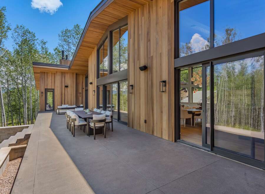 Experience luxurious mountain living with this stunning modern home featuring expansive floor-to-ceiling windows that showcase breathtaking forest views.