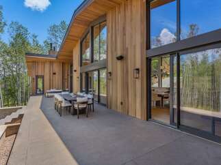Experience luxurious mountain living with this stunning modern home featuring expansive floor-to-ceiling windows that showcase breathtaking forest views.