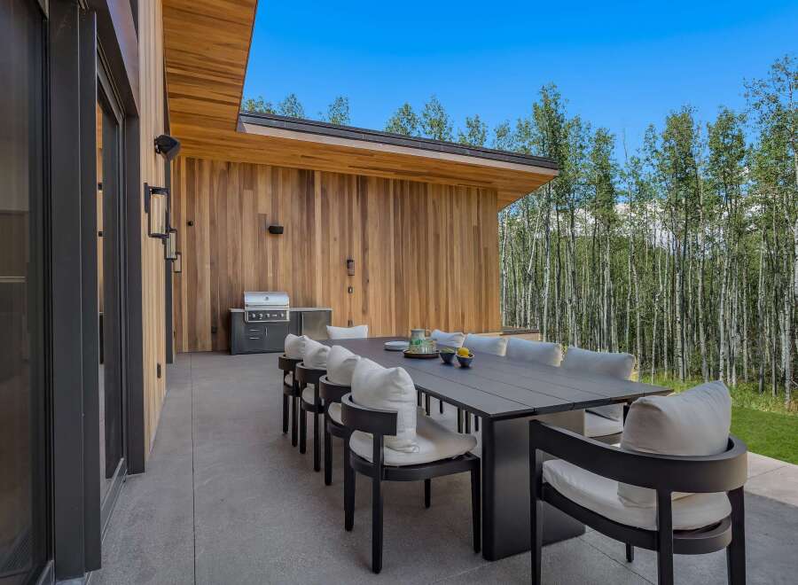 Experience seamless indoor-outdoor living with this stunning modern patio, featuring a spacious dining area perfect for entertaining.