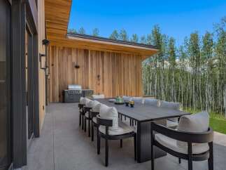 Experience seamless indoor-outdoor living with this stunning modern patio, featuring a spacious dining area perfect for entertaining.