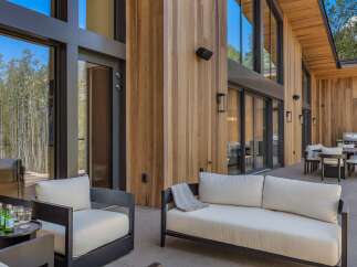 Experience seamless indoor-outdoor living with this stunning modern home, featuring expansive floor-to-ceiling windows that invite natural light and showcase breathtaking forest views.