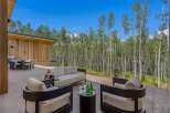 Enjoy outdoor living at its finest on this expansive patio, featuring a modern outdoor dining set and a comfortable seating area perfect for relaxation.