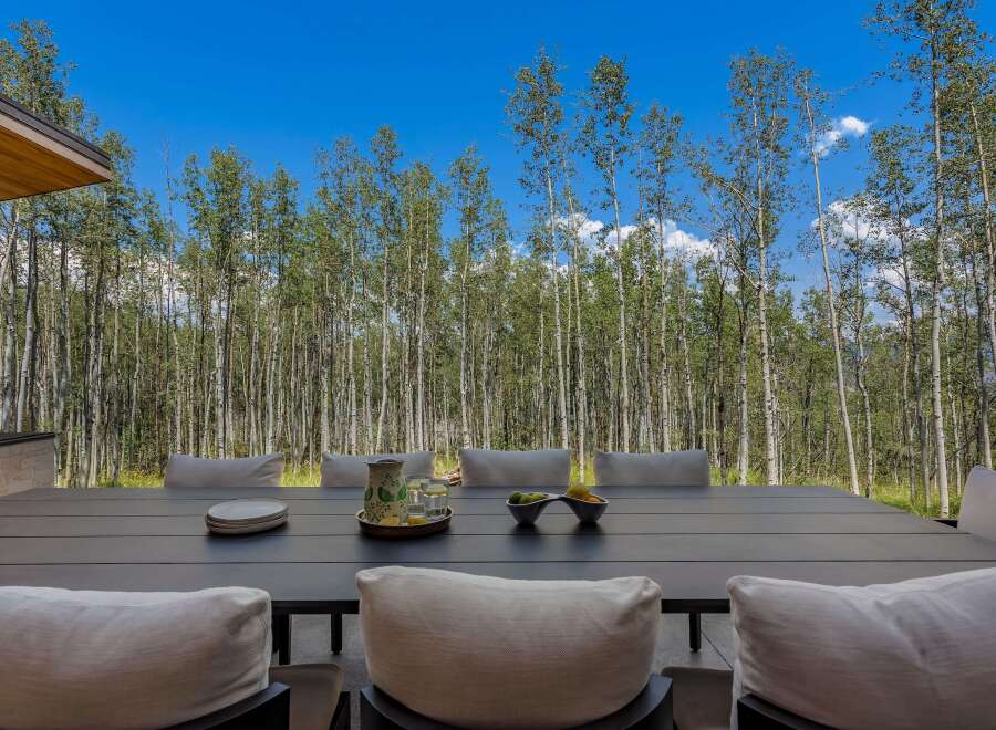 Enjoy al fresco dining with this stunning outdoor patio set, featuring a spacious dark wood table and comfortable seating.