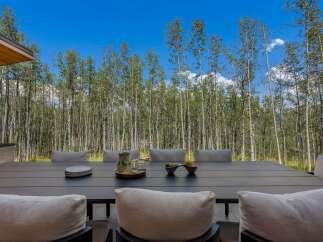 Enjoy al fresco dining with this stunning outdoor patio set, featuring a spacious dark wood table and comfortable seating.