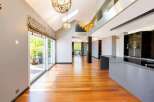 Experience modern luxury in this spacious open-concept living area, featuring gleaming hardwood floors and soaring vaulted ceilings.