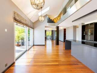 Experience modern luxury in this spacious open-concept living area, featuring gleaming hardwood floors and soaring vaulted ceilings.