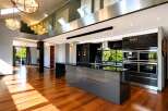 Experience luxury living in this stunning modern home featuring a sleek, open-plan kitchen with high-end appliances and a spacious island.