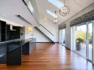 Experience modern luxury in this stunning open-concept living space, featuring a sleek black kitchen with a granite island and integrated appliances.