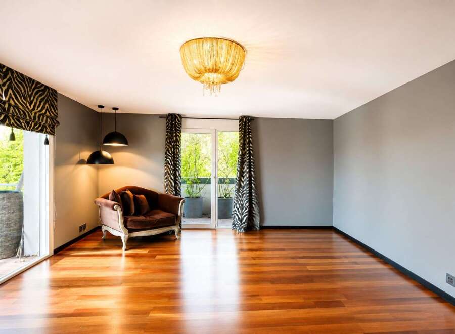 Experience luxurious living in this spacious room featuring a plush velvet sofa and elegant zebra print curtains.