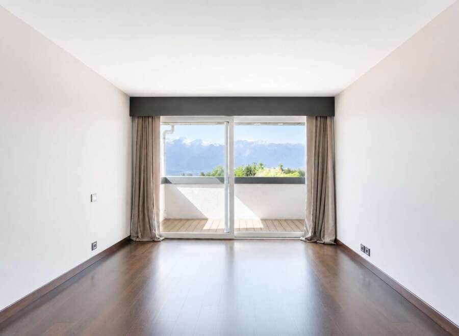 Experience breathtaking mountain and lake views from this spacious room, featuring a large sliding glass door that opens to a private balcony.