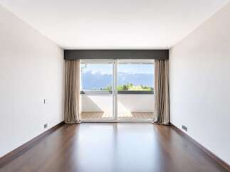 Experience breathtaking mountain and lake views from this spacious room, featuring a large sliding glass door that opens to a private balcony.
