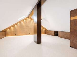 Discover this unique attic space, featuring a striking wave-patterned accent wall illuminated by warm accent lighting.