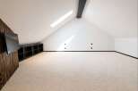 Discover this spacious attic room, perfect for a home theater or entertainment space.