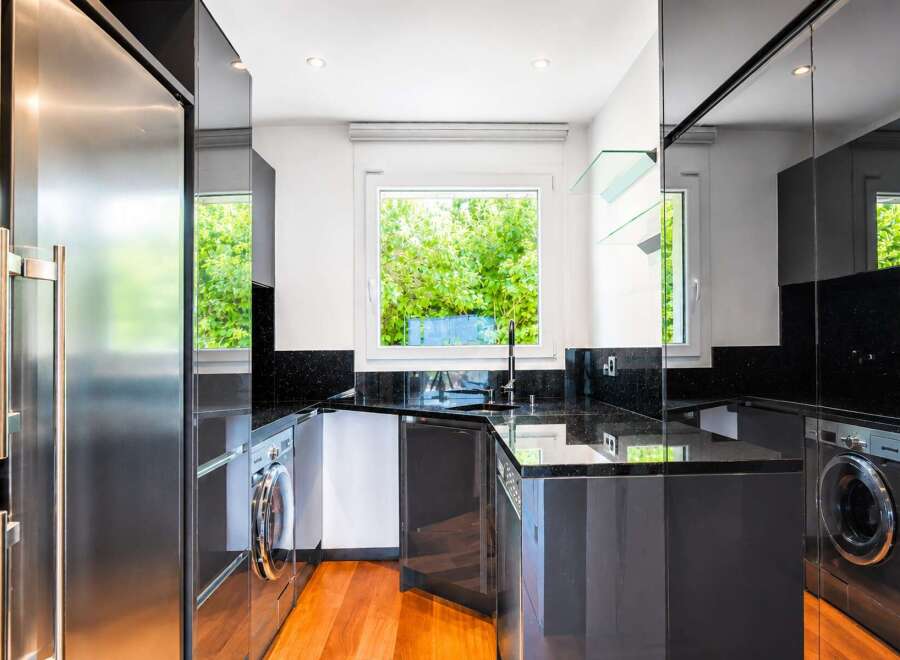 This modern kitchen boasts sleek, dark cabinetry and granite countertops, creating a sophisticated and functional space.