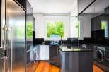 This modern kitchen boasts sleek, dark cabinetry and granite countertops, creating a sophisticated and functional space.