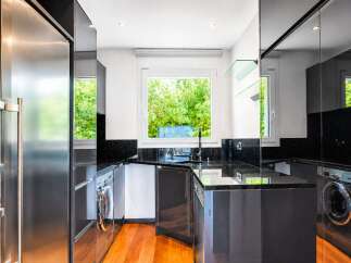 This modern kitchen boasts sleek, dark cabinetry and granite countertops, creating a sophisticated and functional space.