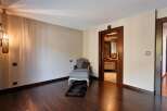 Step into a luxurious master suite featuring a comfortable chaise lounge and ottoman, perfect for relaxation.