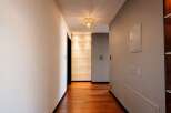 Step into this elegant hallway featuring a stunning crystal chandelier that casts a warm glow.