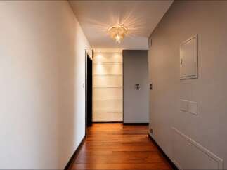 Step into this elegant hallway featuring a stunning crystal chandelier that casts a warm glow.