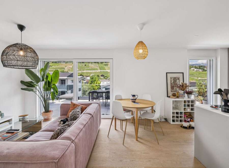 Experience modern living in this bright and airy open-plan space, featuring a stylish pink corduroy sofa and a round dining table perfect for intimate gatherings.