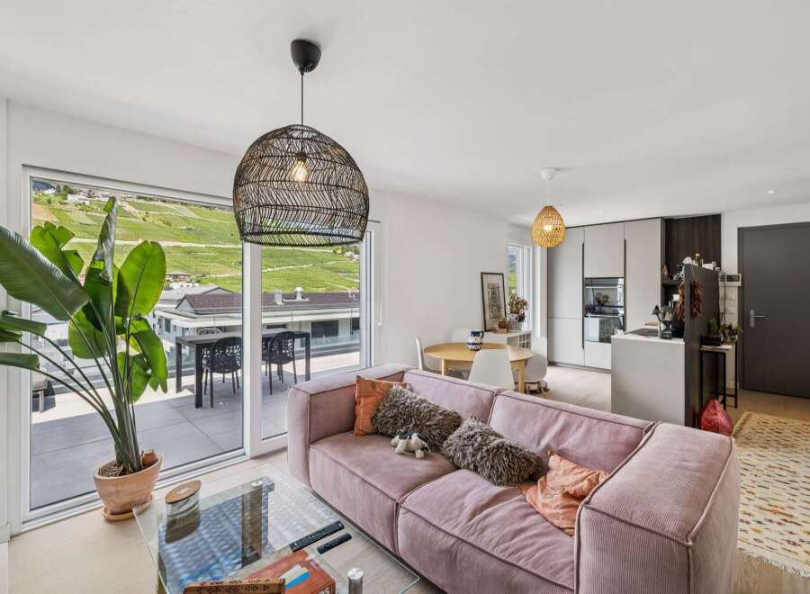 Experience modern living in this stunning apartment featuring a spacious open-plan living area with a plush pink sofa and a large glass coffee table.