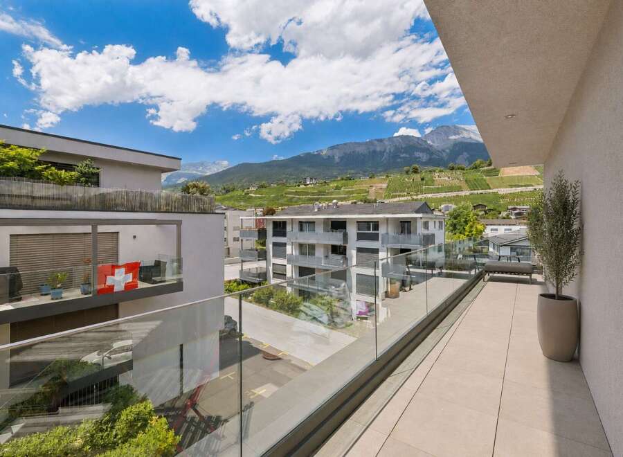 Experience modern living with this stunning balcony offering breathtaking mountain and vineyard views.