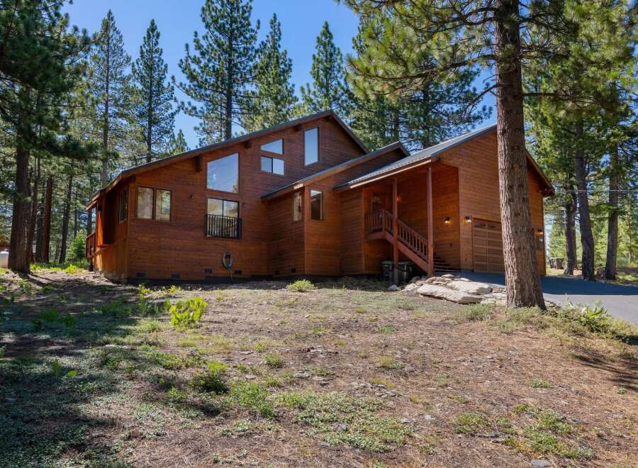 Nestled amongst tall pine trees, this charming wooden home offers a serene mountain retreat.