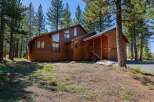 Nestled amongst tall pine trees, this charming wooden home offers a serene mountain retreat.