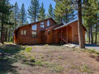 Nestled amongst tall pine trees, this charming wooden home offers a serene mountain retreat.