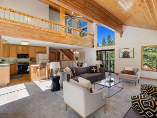 Experience mountain living in this stunning home featuring a spacious open-concept living area with soaring vaulted ceilings and exposed wood beams.