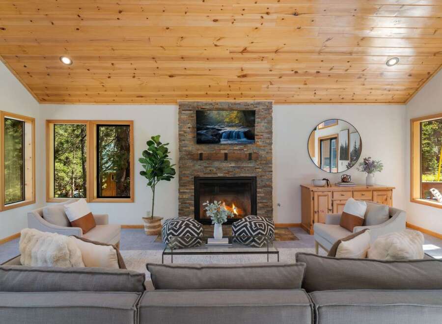 Experience cozy living in this inviting living room, featuring a stunning stone fireplace as the centerpiece.