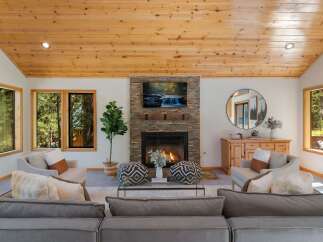 Experience cozy living in this inviting living room, featuring a stunning stone fireplace as the centerpiece.