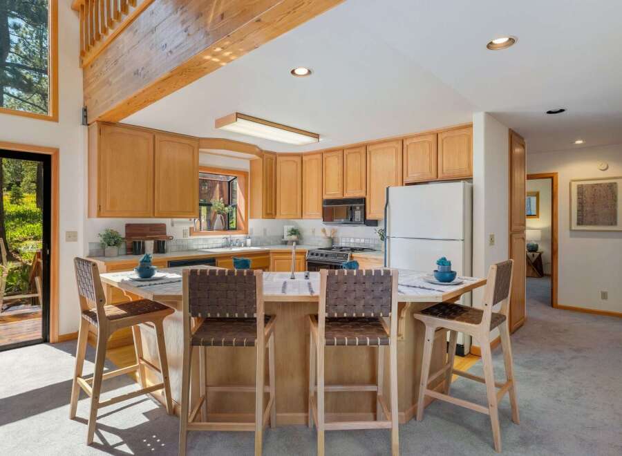 This spacious kitchen features warm, natural wood cabinetry and a large island with seating, perfect for casual dining or entertaining.