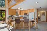 This spacious kitchen features warm, natural wood cabinetry and a large island with seating, perfect for casual dining or entertaining.